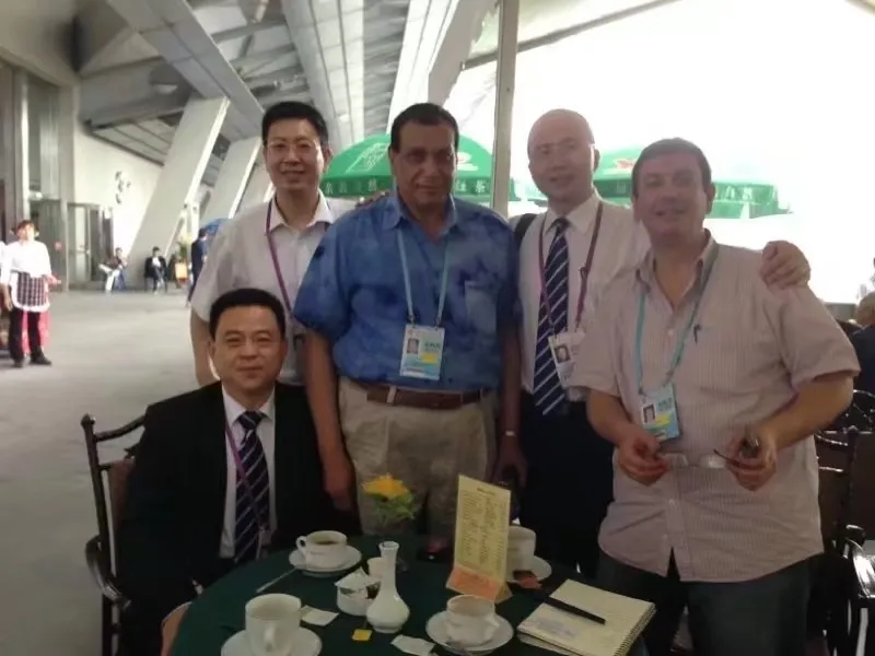 FULI staff and two overseas customers with visitor badges at a café table at a trade fair