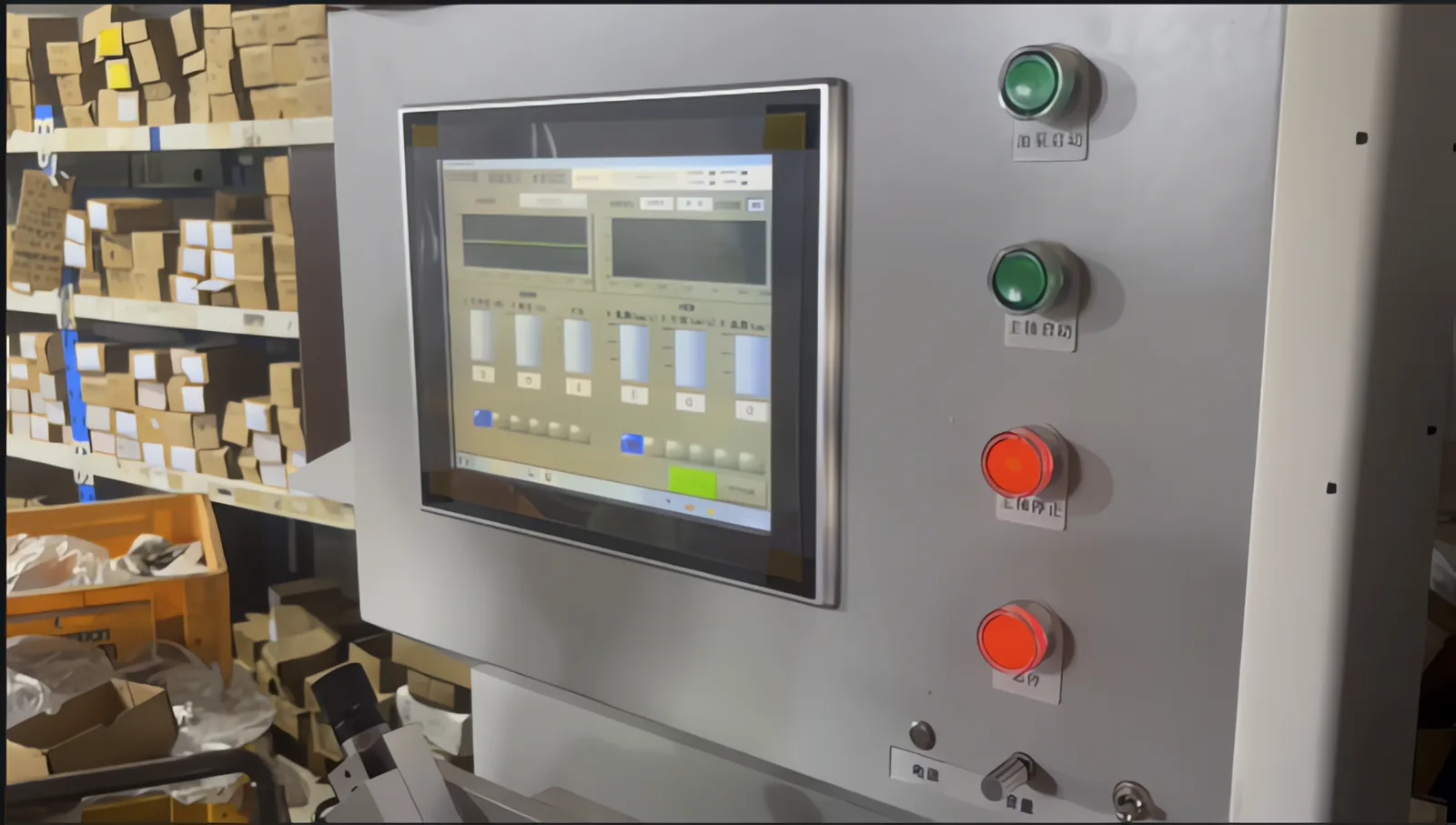 Touchscreen control panel of a bearing test machine with boxed bearings on shelves behind it