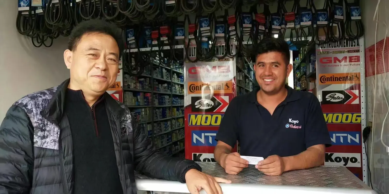 FULI staff member standing at the counter of an overseas bearing and belt shop with the shop owner